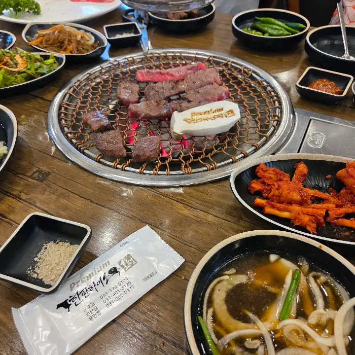 숯불 위에 구워지는 고기와 반찬들