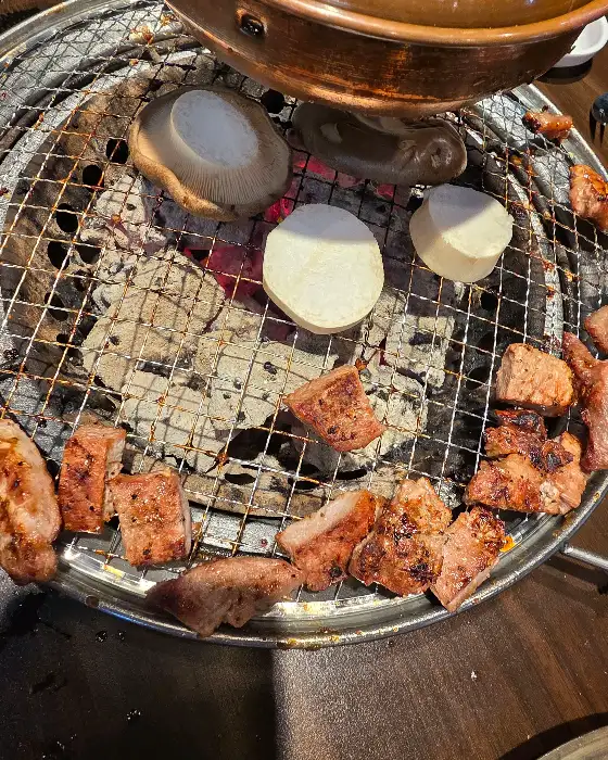 불판 위에서 구워지는 고기와 버섯