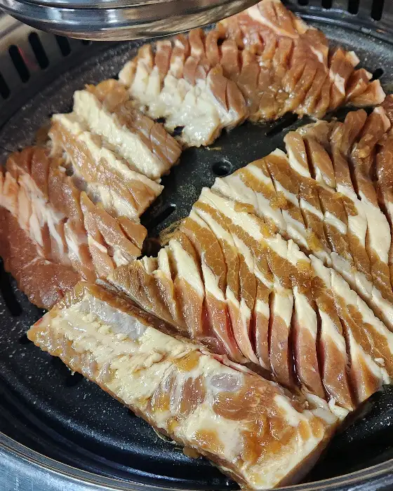 잘 구워진 삼겹살과 양념 돼지갈비가 나란히 놓여있는 모습