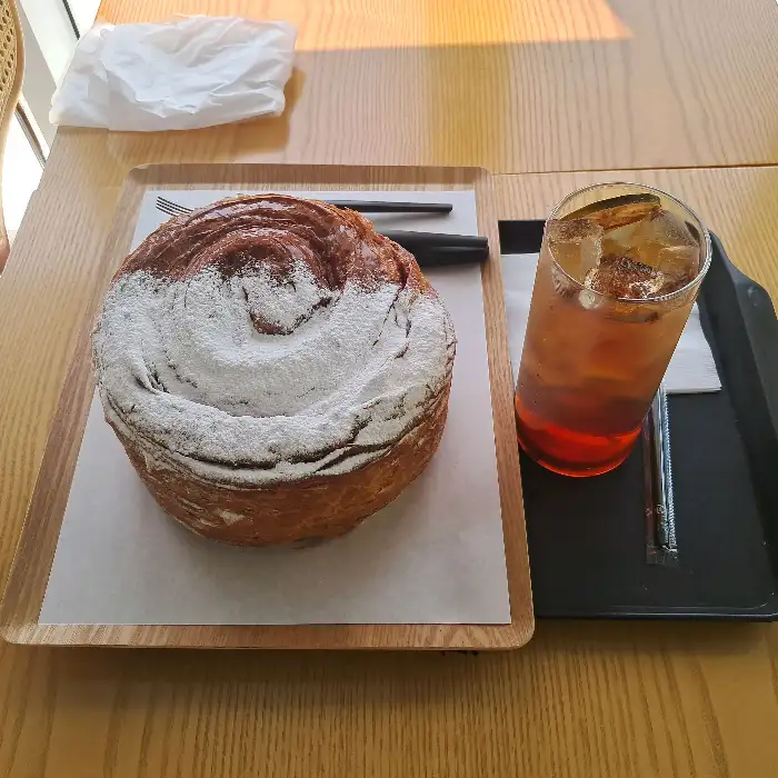가루 설탕이 뿌려진 둥근 빵과 음료