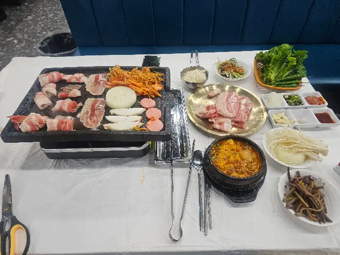 테이블에 차려진 고기, 찌개, 쌈채소 등 푸짐한 한 상