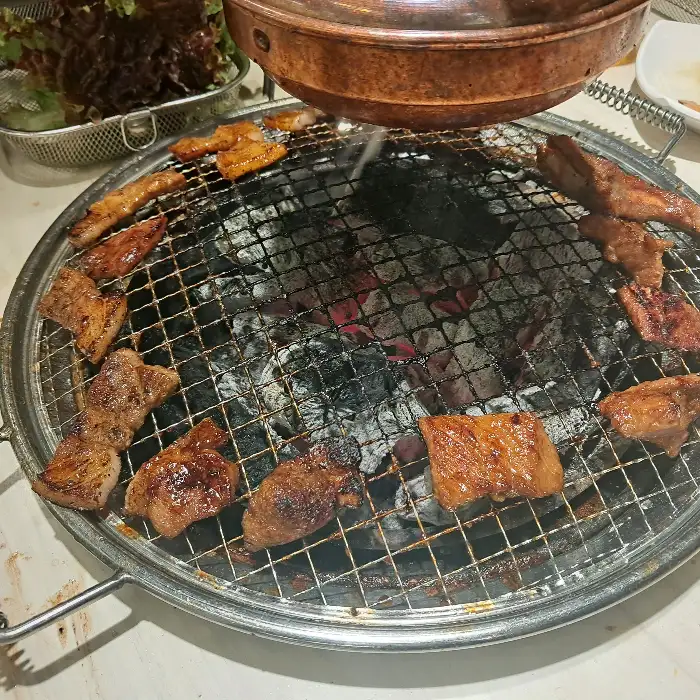 잘 구워진 고기와 샐러드바 메뉴를 함께 즐기는 모습