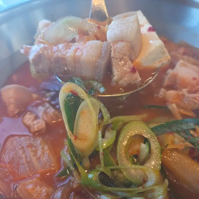 김치찌개 국물에 뜬 돼지고기와 두부