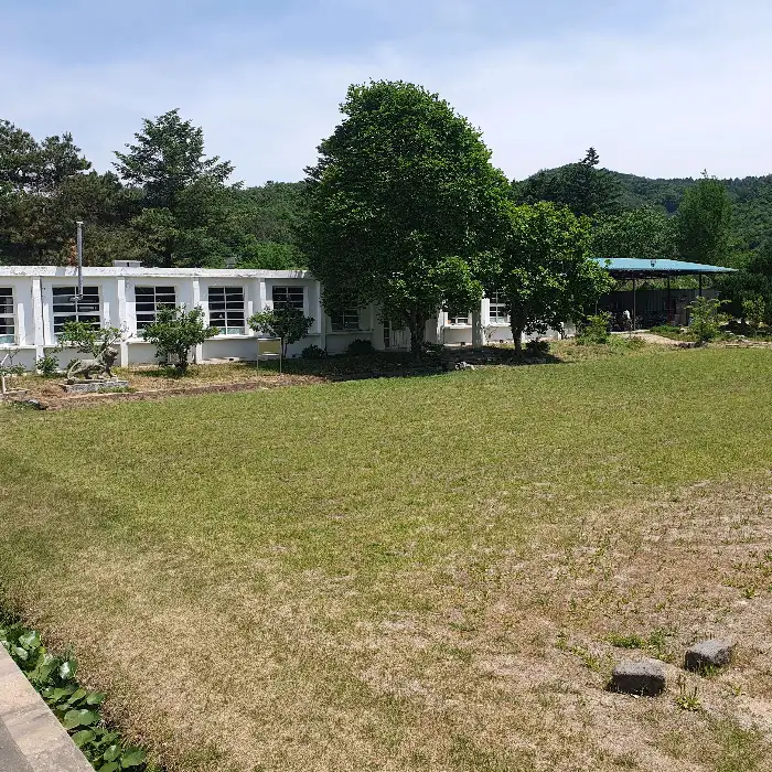 옛 학교 건물의 전경과 넓은 잔디밭