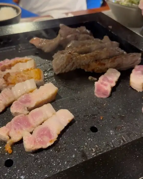 오겹살과 목살이 불판 위에서 구워지는 모습