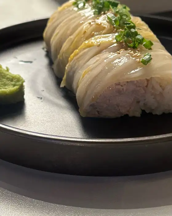 돌돌 말린 묵은지 육회말이가 푸짐하게 담겨 있는 접시
