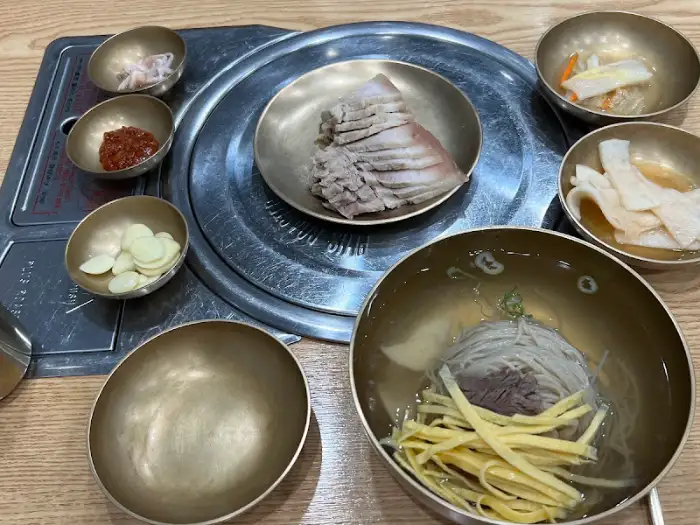 식탁에 차려진 평양냉면과 수육, 그리고 밑반찬들