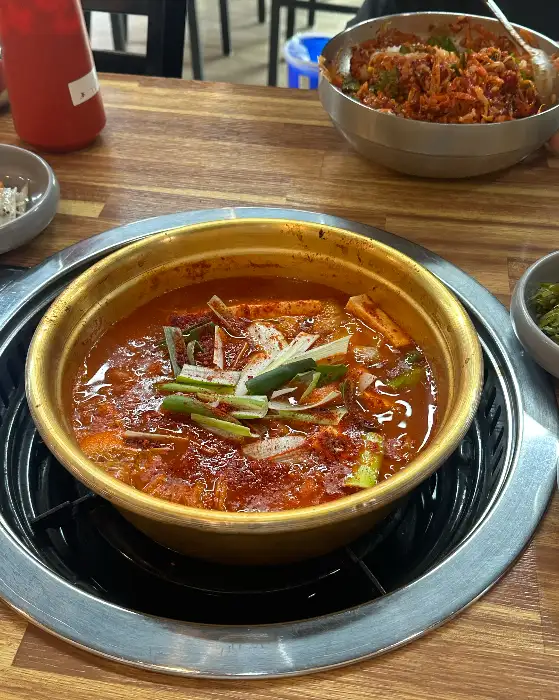 먹음직스러운 김치찌개가 냄비 안에 담겨 있는 모습