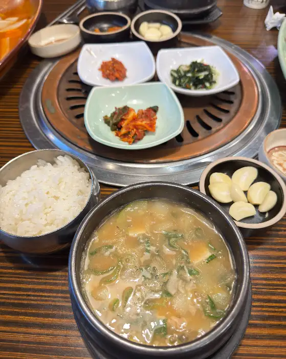 식탁 위에 놓인 밥, 된장찌개, 그리고 쌈 채소와 곁들임 반찬들