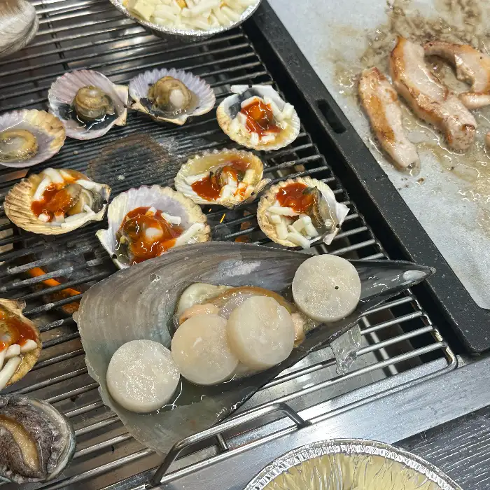그릴 위에서 구워지는 조개와 고기