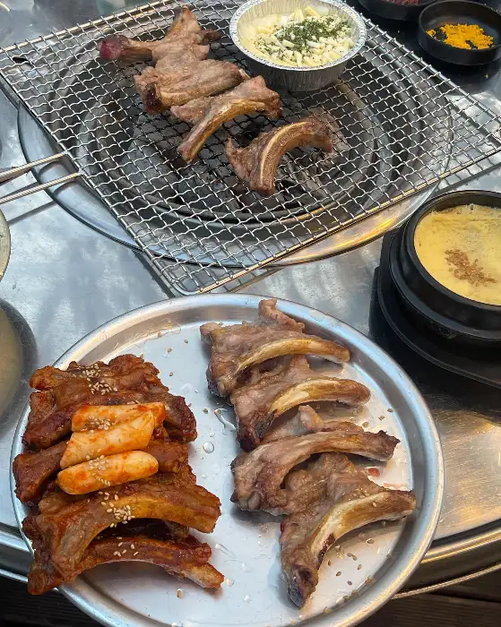 숯불 위에서 익어가는 쪽갈비와 기본 반찬