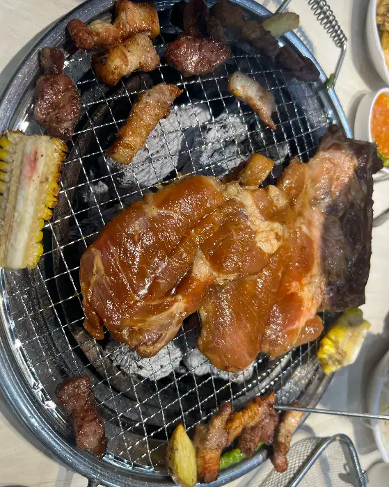 명륜진사갈비 논산점의 숯불 위에서 지글지글 익어가는 맛있는 돼지갈비