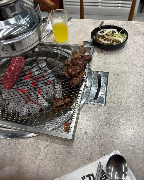 숯불 위에서 구워지는 소고기와 샐러드