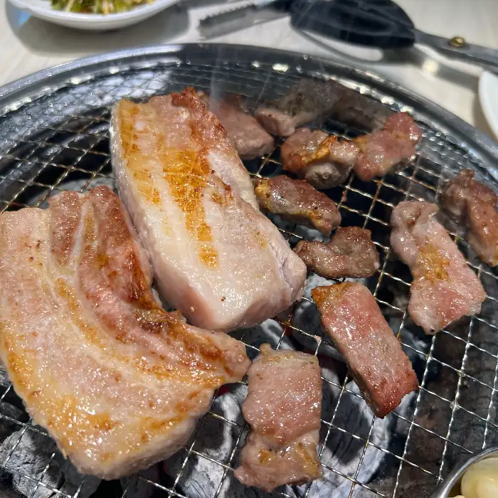 명륜진사갈비 논산점에서 삼겹살과 목살을 굽는 모습