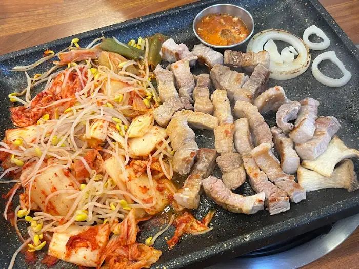 앞접시에 덜어낸 삼겹살과 구운 김치, 콩나물