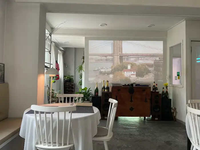 A white tablecloth-covered table in a restaurant with a large projection of a bridge on the wall.