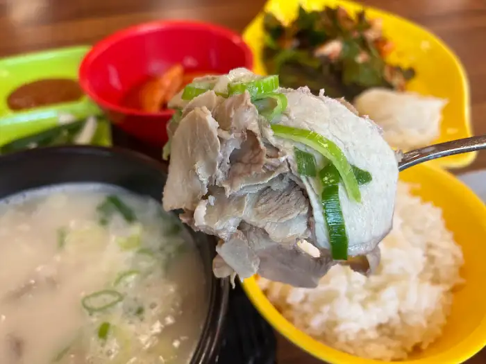 여러 반찬과 국밥, 밥이 차려진 테이블 모습