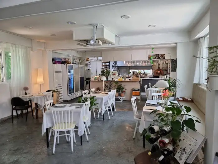Interior view of a restaurant with tables set with white tablecloths and chairs.