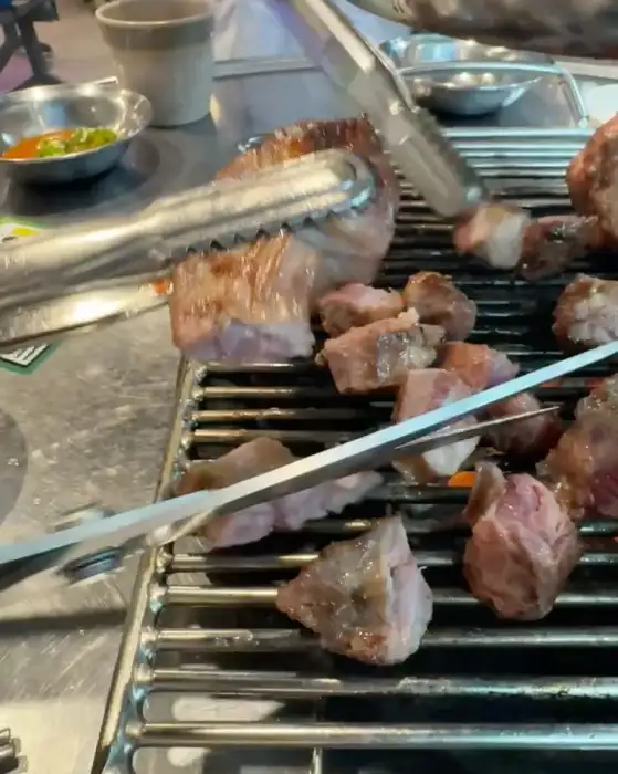 집게로 고기를 뒤집는 모습