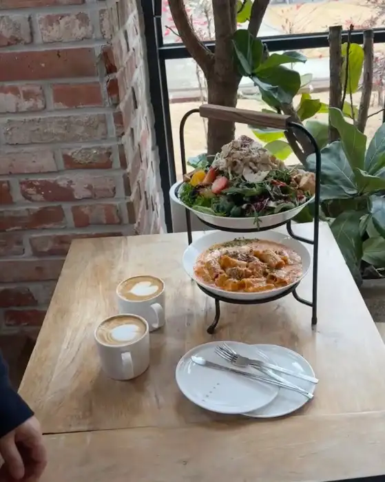 테이블 위에 놓인 따뜻한 라떼와 아이스 아메리카노, 그리고 브런치 메뉴