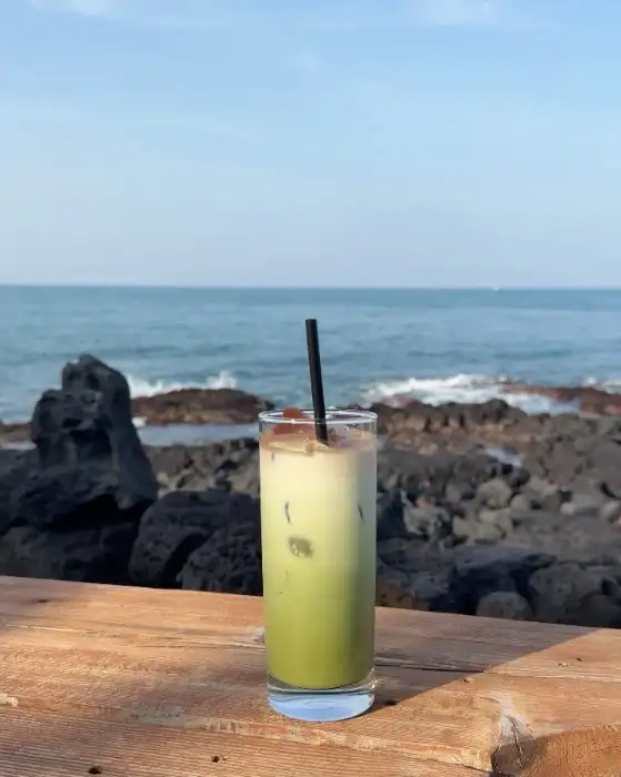 카페 앞에 서 있는 하얀색 강아지, 'PEOPLE CAFE'라고 적힌 간판