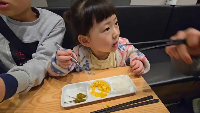어린 아이가 찜닭과 함께 나온 반찬을 먹고 있는 모습
