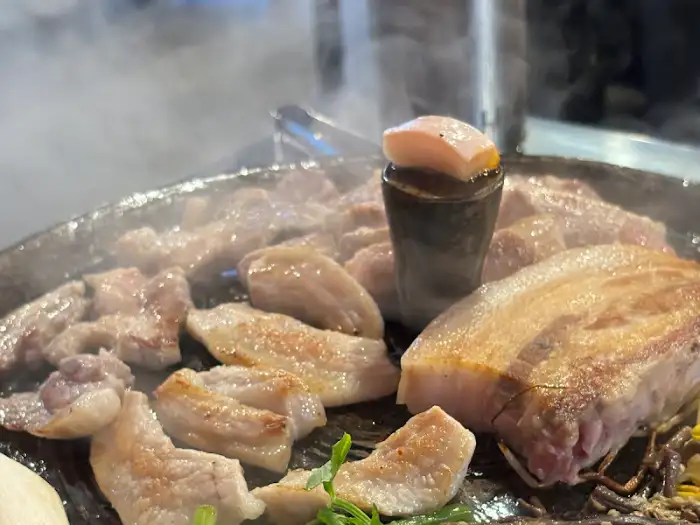 솥뚜껑 위 고기 굽는 모습