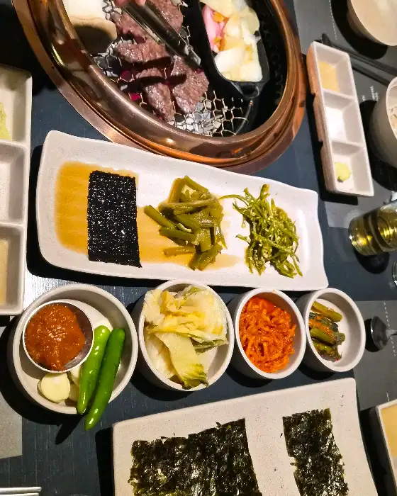 잘 구워진 고기와 함께 곁들임 찬이 준비된 모습