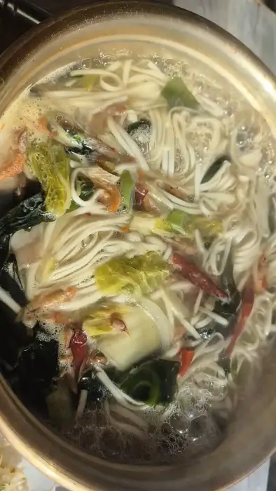 바지락 칼국수에 미역과 면이 가득 담긴 모습