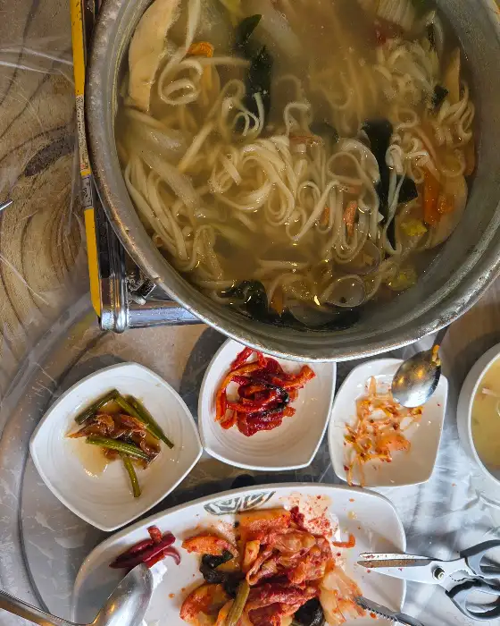 테이블에 차려진 푸짐한 칼국수와 여러 반찬들
