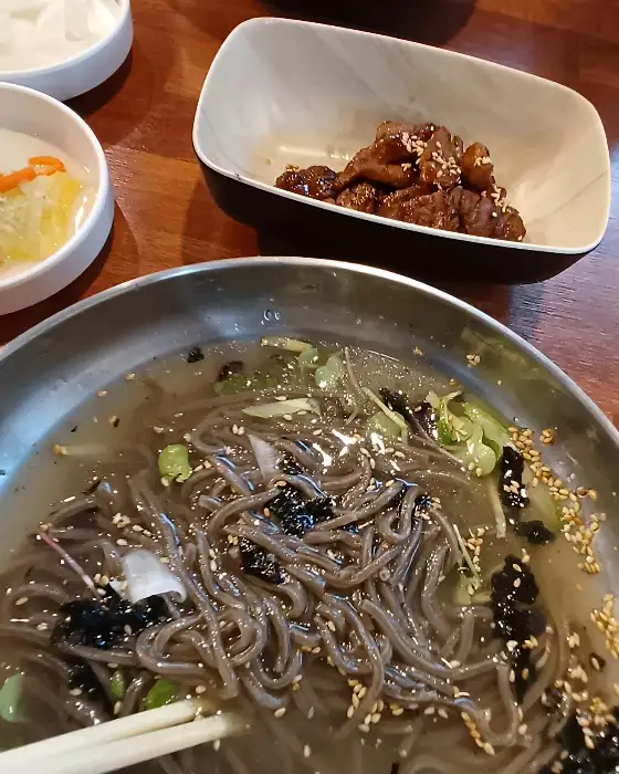 잘 구워진 갈비가 담긴 접시와 막국수