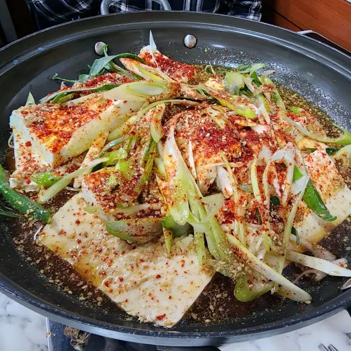 짜박두부에 고춧가루와 파가 뿌려진 모습