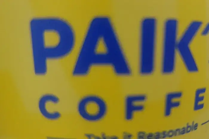 PAIK'S COFFEE 로고가 보이는 노란색 컵 사진