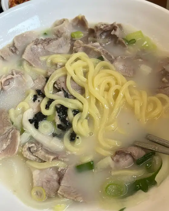 뽀얀 고기국수 안에 얇게 썰어낸 부드러운 고기와 쫄깃한 면발이 가득한 모습