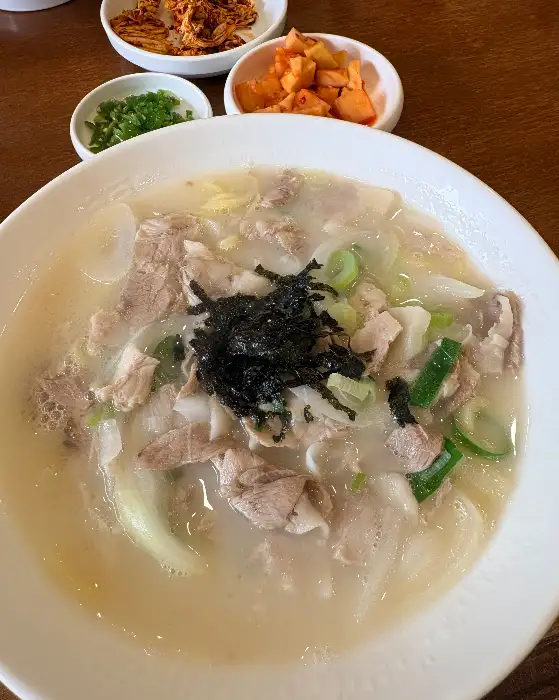 고기국수 한 그릇에 파와 김가루, 그리고 밥이 놓인 모습