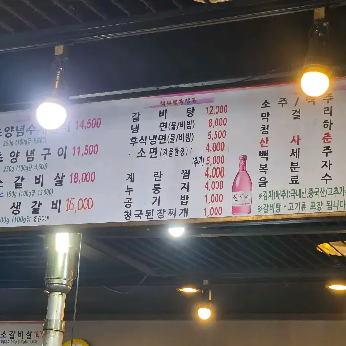 테이블에 차려진 다양한 밑반찬과 숯불이 준비된 불판