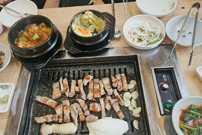 불판 위에서 익어가는 고기와 찌개