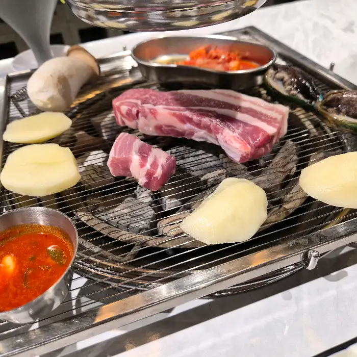신선한 고기와 전복, 버섯이 함께 구워지는 모습