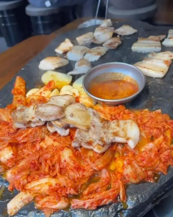 돌판 위에 구워지는 고기, 김치, 감자