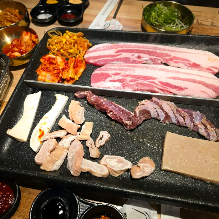 막창, 삼겹살, 벌집 껍데기 등이 불판에 올려져 구워지고 있는 모습