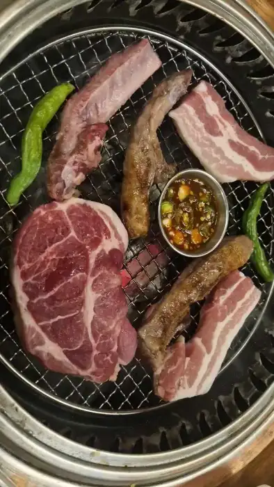 다양한 부위의 돼지고기와 숯불이 준비된 불판