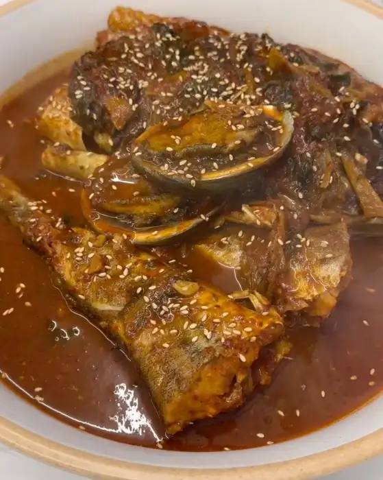 푸짐하게 담긴 생선 요리. 붉은 양념과 함께 윤기가 흘러 먹음직스럽습니다.