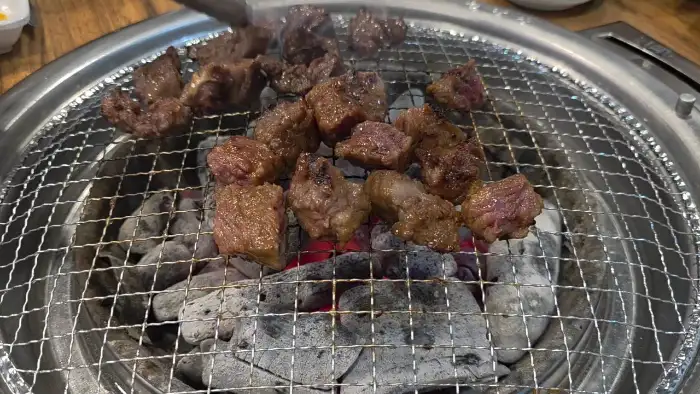 참숯 위에서 익어가는 두툼한 돼지갈비