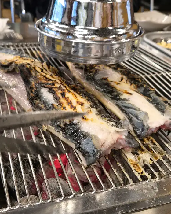 집게로 장어구이를 뒤집는 모습
