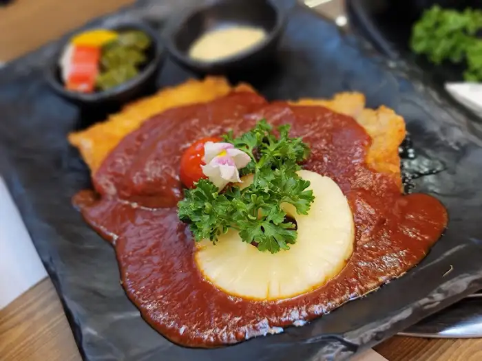 붉은 소스 위에 올려진 먹음직스러운 고기 요리