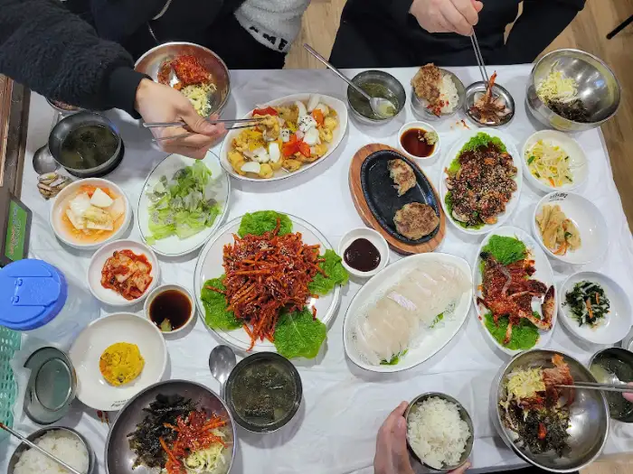 다양한 곁들임 메뉴가 포함된 꼬막정식 상차림