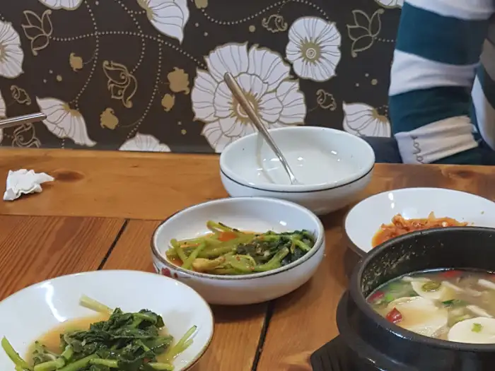 테이블 위에 놓인 여러 가지 반찬과 찌개