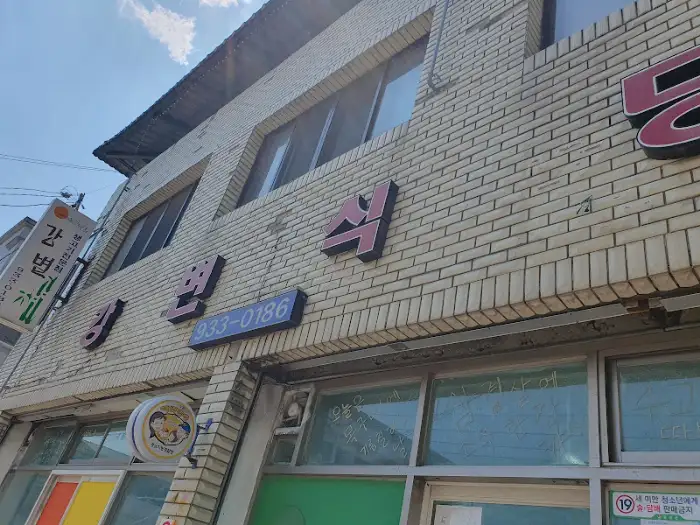 건물 외벽에 부착된 식당 간판과 전화번호