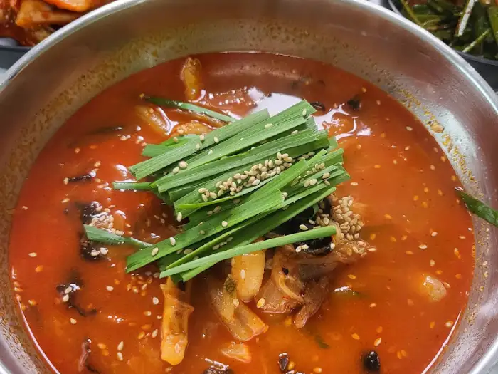 짬뽕순두부밥의 국물 클로즈업 모습. 참깨와 파채가 뿌려져 먹음직스럽습니다.