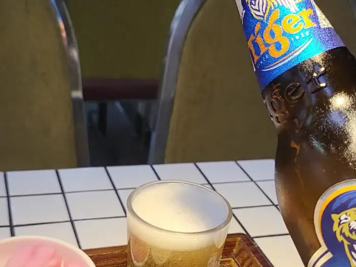 테이블 위 타이거 맥주 병과 맥주가 담긴 잔